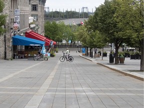 A cyclist has Place Jacques Cartier to himself in Montreal June 30, 2020.
