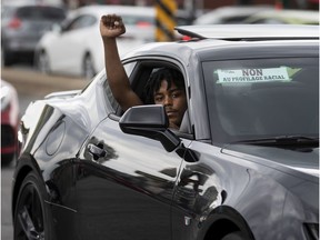 A man shows his support during Sunday's "driving while Black" convoy, protesting racial bias from police.