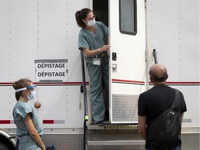 A health care worker gives instructions to people waiting in a long line at a new Covid-19 test site on St. Denis Street in Montreal, on Thursday, July 16, 2020.
