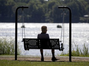A man rests in a newly installed swinging bench in Montreal, on Tuesday, July 28, 2020. The benches are being installed along the shore of the St. Lawrence River in the LaSalle and Verdun boroughs. (Allen McInnis / MONTREAL GAZETTE)