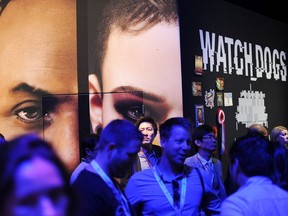 Attendees walk by the display for the game Watch Dogsby Ubisoft, at the Electronic Entertainment Expo (E3) in Los Angeles in this June 12, 2013, file photo.