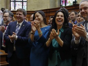 Cathy Wong, centre, and Mayor Valérie Plante applaud after posing for group photos at the last council meeting before the closing of city hall for renovations, in April 2019.