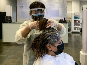 A hairdresser dyes a client's hair at a salon in Riyadh after Saudi Arabia lifted its COVID-19 lockdown.