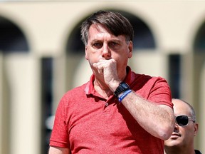 IIn this file photo taken on April 19, 2020, Brazilian President Jair Bolsonaro coughs as he speaks after joining his supporters who were taking part in a motorcade to protest against quarantine and social distancing measures to combat the new coronavirus outbreak in Brasilia.