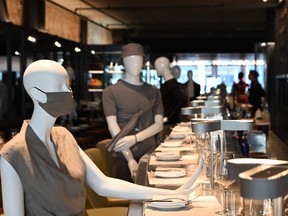 Mannequins are placed at the bar to provide social distancing at a restaurant in Old Montreal on July 10, 2020.