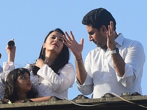 In this file photo taken on March 22, 2020, Bollywood actors Abhishek Bachchan, right, and Aishwarya Rai Bachchan along with their daughter Aaradhya clap from atop a residential building to thank essential service providers during a one-day Janata (civil) curfew imposed amid concerns over the spread of the COVID-19 novel coronavirus, in Mumbai. Aishwarya Rai has tested positive for the coronavirus, a Mumbai city authority official told AFP on Sunday, July 12, only a day after her father-in-law Amitabh Bachchan said he was in hospital with the infectious disease. Her eight-year-old daughter, Aaradhya, was also COVID-19 positive, the Brihanmumbai Municipal Corporation official, who asked to remain anonymous, said.