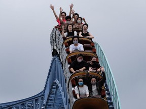 Visitors take a ride on a rollercoaster at the Toshimaen amusement park in Tokyo on July 13, 2020. (Photo by Kazuhiro NOGI / AFP)