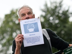 A man in London holds up a placard as people gather to listen to speakers at a protest organized by "Keep Britain Free" on July 19, 2020, in response to the government's decision to impose mask wearing for shoppers as a precaution against the transmission of the novel coronavirus. The placard suggests that masks are a mind-control device.