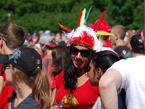 (FILES) In this file photo taken on June 28, 2013 a woman wearing a feather headdress is among tens of thousands of fans who filled the streets of Chicago to cheer on the Blackhawks for winning the Stanley Cup. - The Chicago Blackhawks have refused to change their name but on July 29 the National Hockey League club banned supporters from wearing Native American headdresses at games. (Photo by MIRA OBERMAN / AFP)