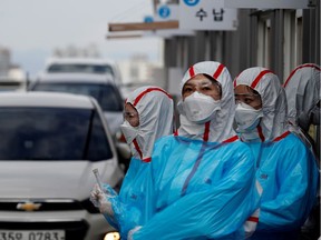 Medical staff in protective gear work at a 'drive-thru' testing center for the novel coronavirus disease of COVID-19 in Yeungnam University Medical Center in Daegu, South Korea, March 3, 2020. REUTERS/Kim Kyung-Hoon/File Photo