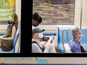 People wear face masks as they commute on the métro in Montreal on Sunday, July 12, 2020, as the COVID-19 pandemic continues in Canada and around the world. Mask wearing becomes mandatory on all public transit in Quebec as of July 13.