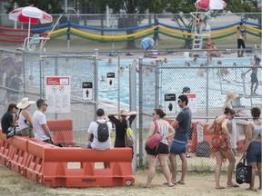 CP-Web. People wait in line to get into a community pool in Montreal, Sunday, June 21, 2020.