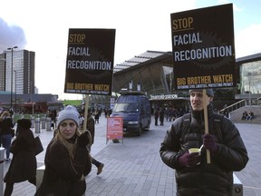 People demonstrate in front of a mobile police facial recognition facility outside a shopping centre in London on Feb. 2020. Dozens of groups and individuals working to protect privacy, human rights and civil liberties want the Trudeau government to ban the use of facial-recognition surveillance by federal law-enforcement and intelligence agencies.
