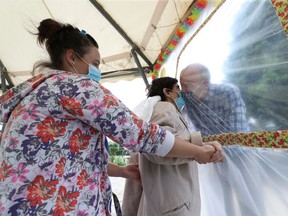 Luigia Pani, 89, a resident at Belgian nursing home  Le Jardin de Picardie  enjoy hugs and cuddles with her son Riccardo Vacca through a wall made with plastic sheets to protect against potential coronavirus disease (COVID-19) infection, in Peruwelz, Belgium July 1, 2020. Picture taken July 1, 2020.