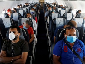 FILE PHOTO: Passengers wearing protective face masks sit on a plane at Sharm el-Sheikh International Airport, following the outbreak of the coronavirus disease (COVID-19), in Sharm el-Sheikh, Egypt, June 20, 2020. REUTERS/Mohamed Abd El Ghany/File Photo