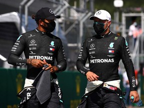 Austrian Grand Prix, July 4, 2020:   Mercedes' Lewis Hamilton and Mercedes' Valtteri Bottas wear protective face masks after qualifying, as F1 resumes.