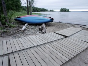 Upturned canoes lie  on a nearly deserted beach at Cap St Jacques