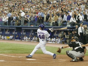 Expos' Terrmel Sledge hits a fly ball in the team's final at-bat in history at Olympic Stadium on Sept. 29, 2004.