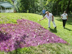 Staff and family place flowers on a giant heart at the CHSLD Ste-Dorothée on Wednesday, July 15, 2020 during a ceremony to remember the 101 residents who have died of COVID-19.