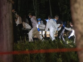 A body believed to be Martin Carpentier is carried by police investigators Monday night in St-Apollinaire.