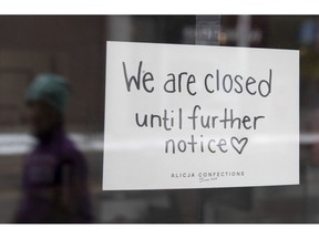 A sign on a shop window indicates the store is closed in Ottawa, Monday March 23, 2020. Companies that have laid off workers are telling the Bank of Canada they plan to refill some positions over the next year, but many hiring plans remain muted over COVID-19-related uncertainty.