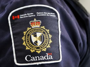A Canada Border Services Agency (CBSA) patch is seen on an officer in Calgary, Alta., Thursday, Aug. 1, 2019. Canada Border Services Agency is imposing stricter rules for non-essential travellers transiting through Canada to Alaska in order to minimize the time that American travellers spend in Canada.THE CANADIAN PRESS/Jeff McIntosh