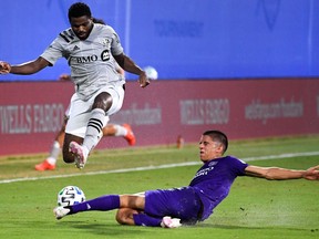 Orlando City SC defender Joao Moutinho (4) tackles Montreal Impact forward Orji Okwonkwo (18) during the first half at ESPN Wide World of Sports Complex in Reunion, Fla., on Saturday, July 24, 2020.