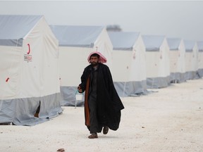 FILE PHOTO: A displaced Syrian man walks past by tents supplied by Turkish Red Crescent at Kelbit camp, near the Syrian-Turkish border, in Idlib province, Syria January 17, 2018. Picture taken January 17, 2018. REUTERS/Osman Orsal/File Photo