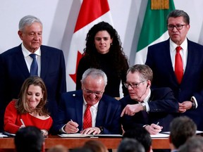 Mexico's President Andres Manuel Lopez Obrador looks on as Canadian Deputy Prime Minister Chrystia Freeland, Mexican Deputy Foreign Minister for North America Jesus Seade, and U.S. Trade Representative Robert Lighthizer sign documents during a meeting at the Presidential Palace, in Mexico City, Mexico December 10, 2019. REUTERS/Henry Romero/File Photo