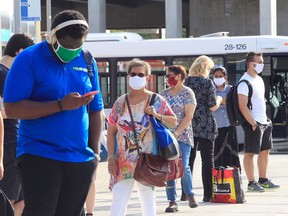 People line up for the bus at the Vendôme Metro station on the first day masks are mandatory on public transit in Quebec.