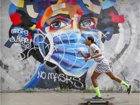 Anne Marie Louis-Charles skateboards past a mural on Cloutier St. in Montreal Monday August 3, 2020. (John Mahoney / MONTREAL GAZETTE)