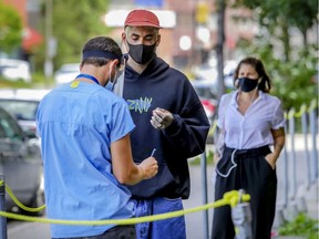 Head nurse Sasha Dyck, left, screens Eric Johnson outside a coronavirus testing clinic in Montreal Monday August 3, 2020.