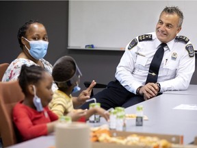 Longueuil police Chief Fady Dagher speaks with Masabatha Kakandjika and some of her children after they visited the police headquarters in Longueuil on Wednesday.
