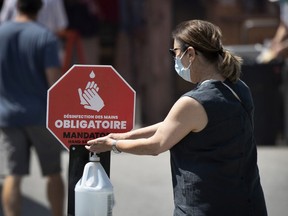 A woman washes her hands as she enters the Atwater Market in Montreal, on Thursday, August 6, 2020.