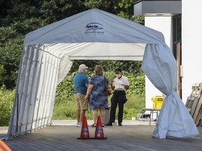 A couple answer questions in the screening tent at the COVID-19 testing centre in Beaconsfield on Aug. 6, 2020.