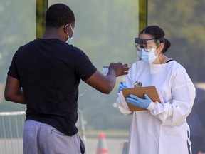 A man shows his ID while in line at the COVID-19 testing centre at the Gerry-Robertson Community Centre in Pierrefonds on Thursday August 6, 2020.