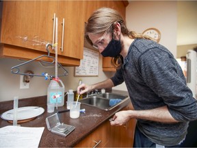 Concordia University student Christopher Spencer conducts a chemistry experiment near the kitchen sink of his apartment in Lachine. Spencer was among nearly 100 students who  took an entry-level chemistry class featuring labs remotely. Students purchased kits containing necessary equipment and used common household items including vinegar and salt in place of chemicals they would have used at the university.