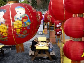 With many dining rooms closed or reduced in size, people eat their food in a public square decorated with lanterns in the Chinatown district of Montreal, on Monday, August 17, 2020.