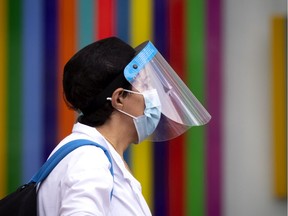 A daycare worker does her best to keep herself and the children safe by wearing a face shield, a face mask, disposable gloves and a washable lab coat as she walks with the children in Montreal on Friday, Aug. 21, 2020.