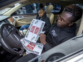 Mickey Jean and Laurence Cajou with leaflets during Driving while Black protest in Montreal on Sunday, Aug. 30, 2020.