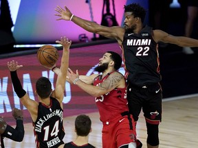 Fred VanVleet #23 of the Toronto Raptors shoots between Jimmy Butler #22 and Tyler Herro #14 of the Miami Heat in the second half at HP Field House at ESPN Wide World Of Sports Complex on August 3, 2020 in Lake Buena Vista, Florida.