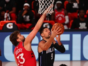Nikola Vucevic of the Orlando Magic goes up for a shot against Marc Gasol of the Toronto Raptors in the first half at Visa Athletic Center at ESPN Wide World Of Sports Complex on August 5, 2020 in Lake Buena Vista, Fla.