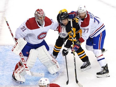 Sidney Crosby #87 of the Pittsburgh Penguins is sandwiched between Carey Price #31 and Brett Kulak #77 of the Montreal Canadiens in the first period in Game One of the Eastern Conference Qualification Round prior to the 2020 NHL Stanley Cup Playoffs at Scotiabank Arena on August 01, 2020 in Toronto, Ontario.