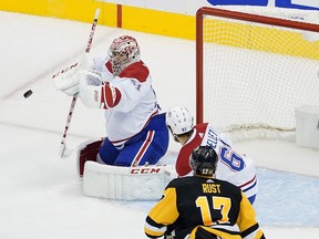 Canadiens goalie Carey Price makes one of his 35 saves as Habs defenceman Xavier Ouellet battles Penguins' Bryan Rust in front of the net Monday night.