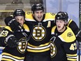 Patrice Bergeron of the Boston Bruins (centre) scores at 1:13 of the second overtime against the Carolina Hurricanes during the second overtime period and is joined by Brad Marchand, left, and Torey Krug, right in Game 1 of the Eastern Conference First Round during the 2020 NHL Stanley Cup Playoffs at Scotiabank Arena on Aug. 12, 2020 in Toronto.