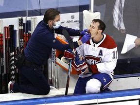 Brendan Gallagher #11 of the Montreal Canadiens is treated by the trainer after sustaining an injury against the Philadelphia Flyers during the third period in Game Five of the Eastern Conference First Round during the 2020 NHL Stanley Cup Playoffs at Scotiabank Arena on August 19, 2020 in Toronto, Ontario.