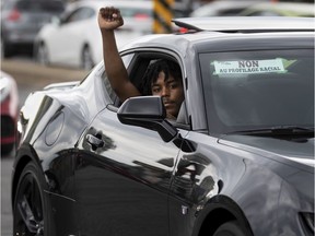 A man shows his support for the BLM movement during a "Driving while Black" convoy and gathering that criss crossed Montreal, on Sunday, July 5, 2020. Section 636 of the Quebec Highway Safety Code is what enables Charter right violations that so frequently target racialized persons, lawyer Ralph Mastromonaco writes.