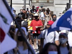 Participants march along Wellington Street as they head to the former NCC as part of the Long Walk Home and Emancipation Day celebrations in Montreal, on Saturday, Aug. 1, 2020.