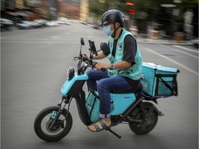 Mask-wearing food delivery man rides on the de Maisonneuve bike path in Montreal Monday August 24, 2020. (John Mahoney / MONTREAL GAZETTE)