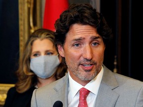 Prime Minister Justin Trudeau speaks to reporters as Deputy Prime Minister Chrystia Freeland, also newly appointed as finance minister, listens on Aug. 18, 2020. Trudeau has asked Gov. Gen. Julie Payette to prorogue Parliament until Sept. 23.